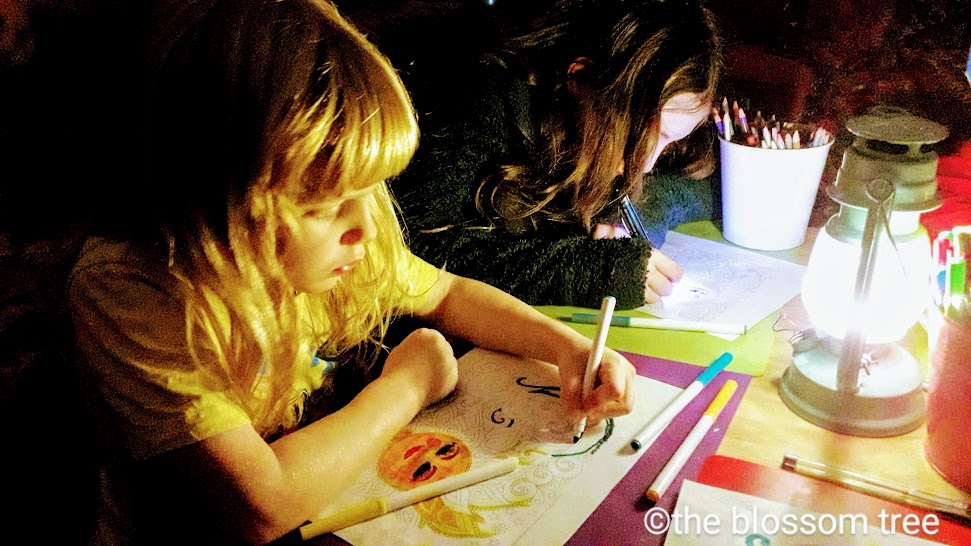 Children working quietly at a table with a lantern